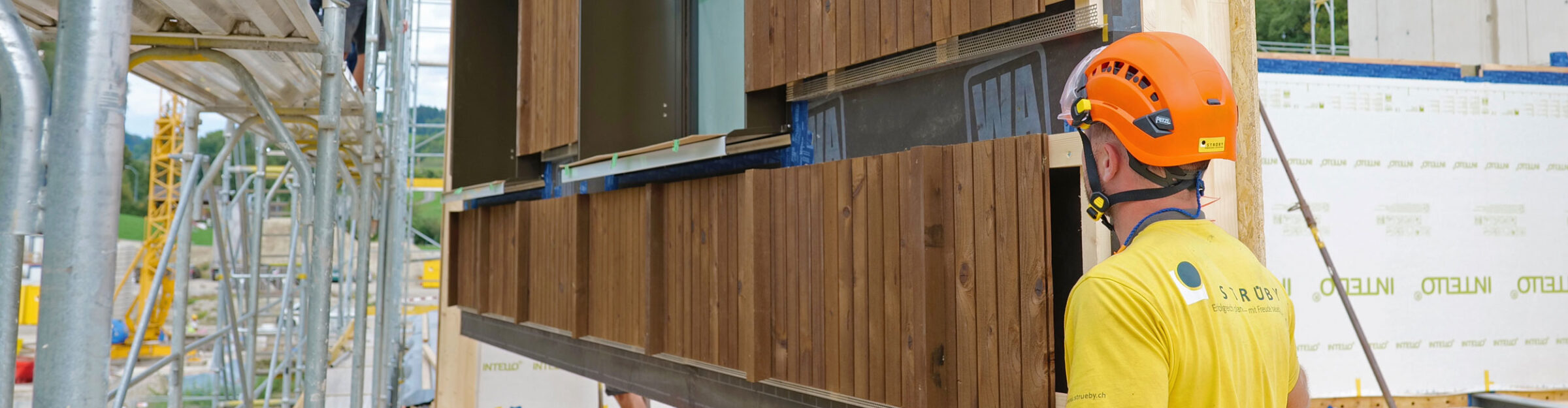 Strüby Unternehmungen Zimmermann auf Baustelle mit Holzelement beim Aufrichten